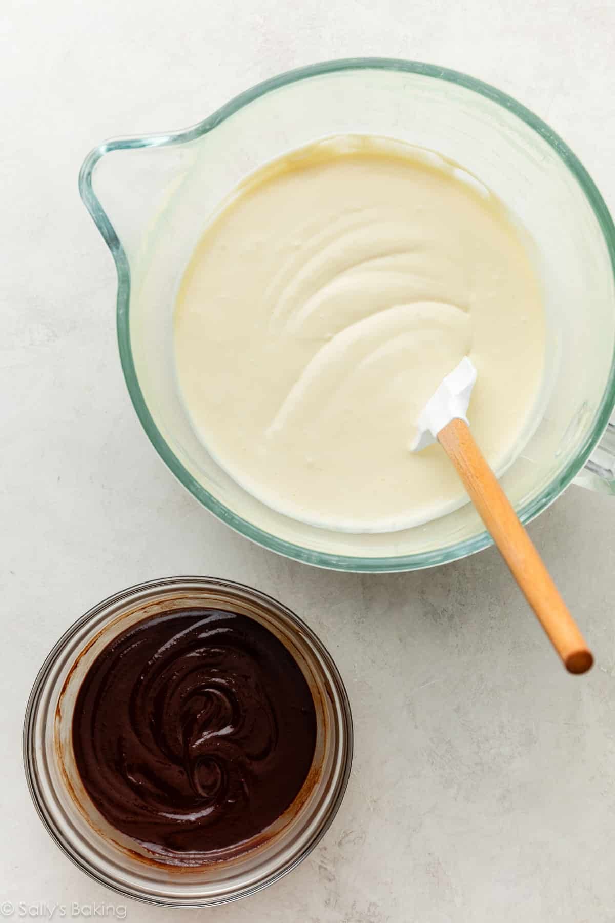 bowl of melted chocolate next to bowl of cheesecake batter.